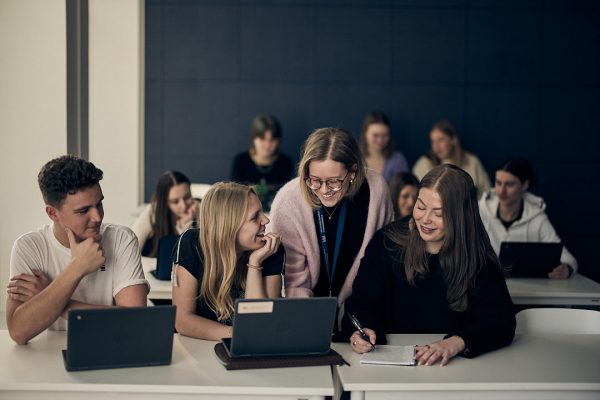 Två elever och en lärare vid en dator