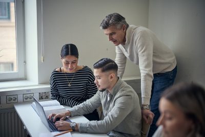 Två elever och en lärare i ett klassrum