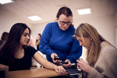 Lärare hjälper elev att ta blodtryck på en klasskompis