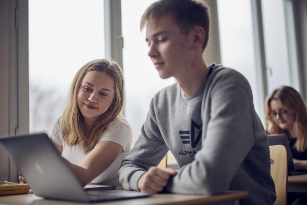 Två elever hjälps åt med en uppgift på datorn