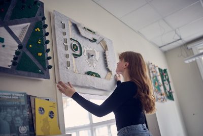 elev hänger upp en tavla på väggen